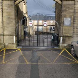Wrought iron electric gate including school logo